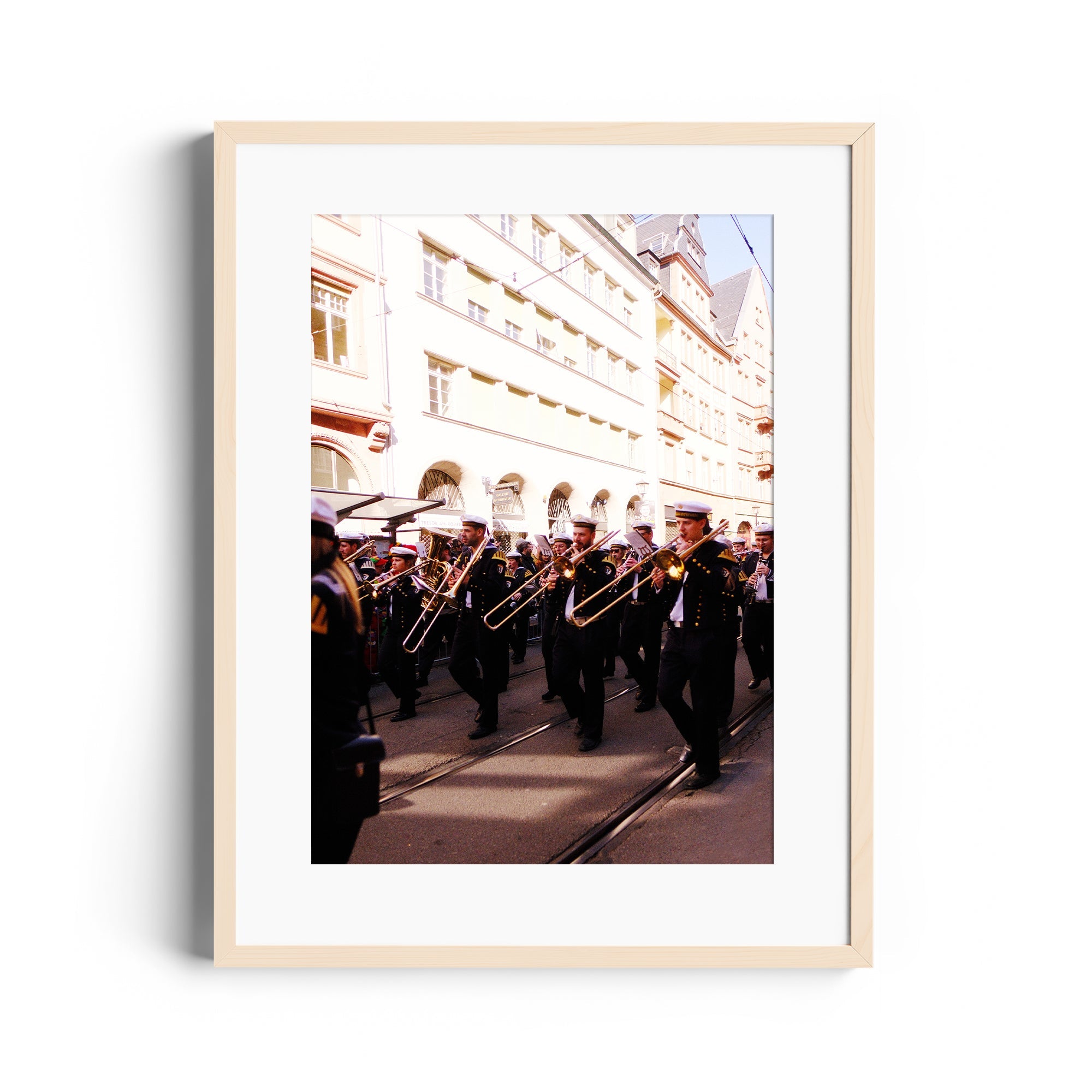 Framed fine art photography of a brass band marching in a city street, capturing movement and musical elegance.