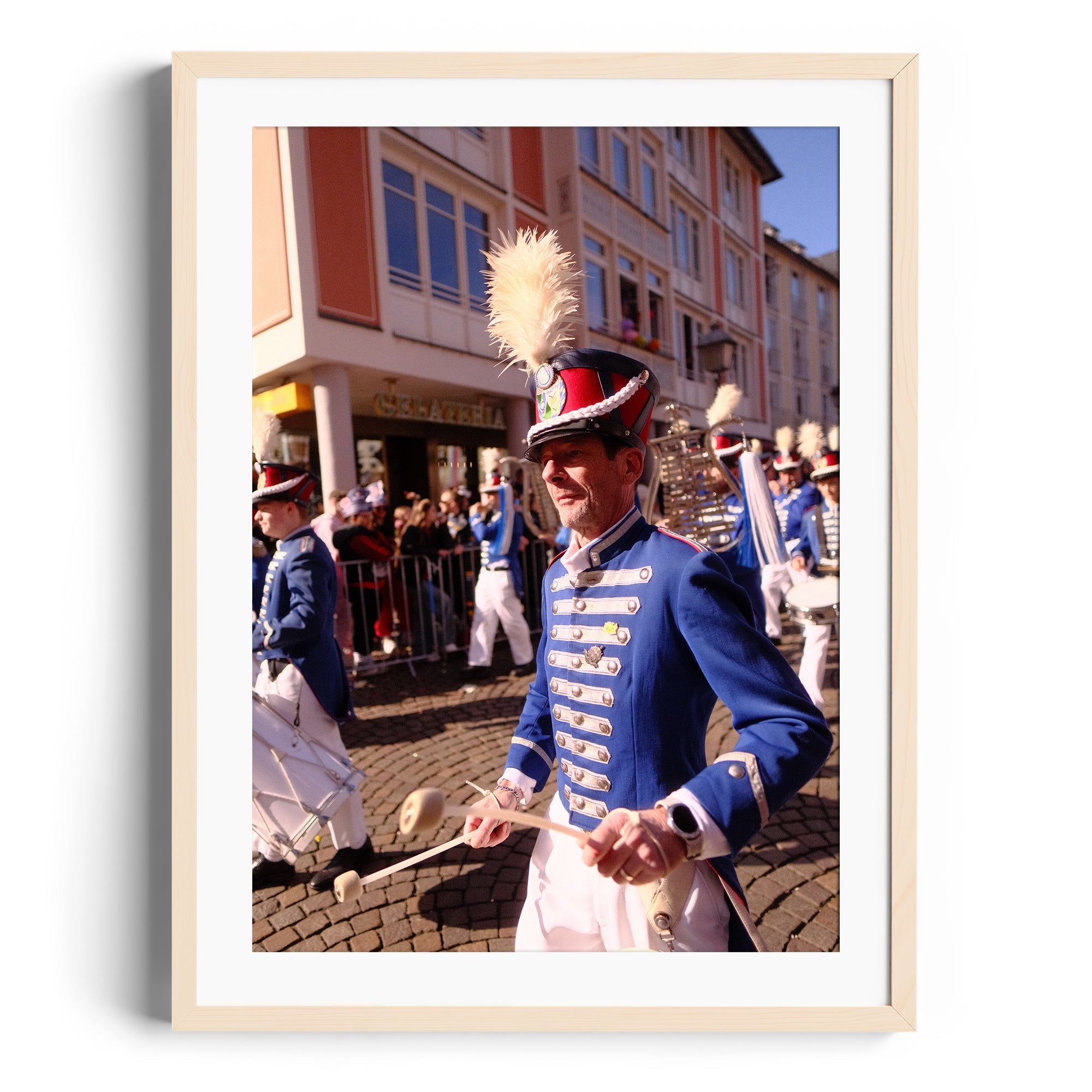 Marching band member in crisp blue uniform with feathered hat, captured during a parade in Wiesbaden, Germany.