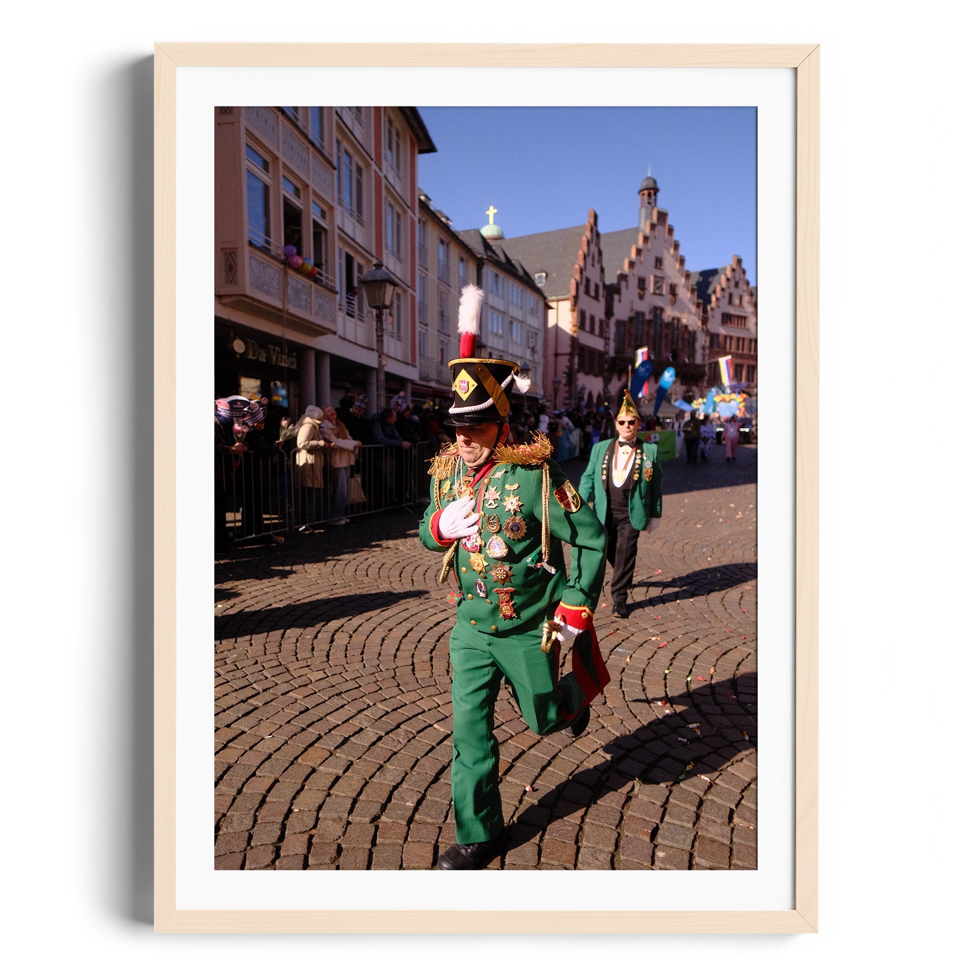 Colorful parade scene showing a soldier in a green uniform amidst historic buildings, capturing festive atmosphere.