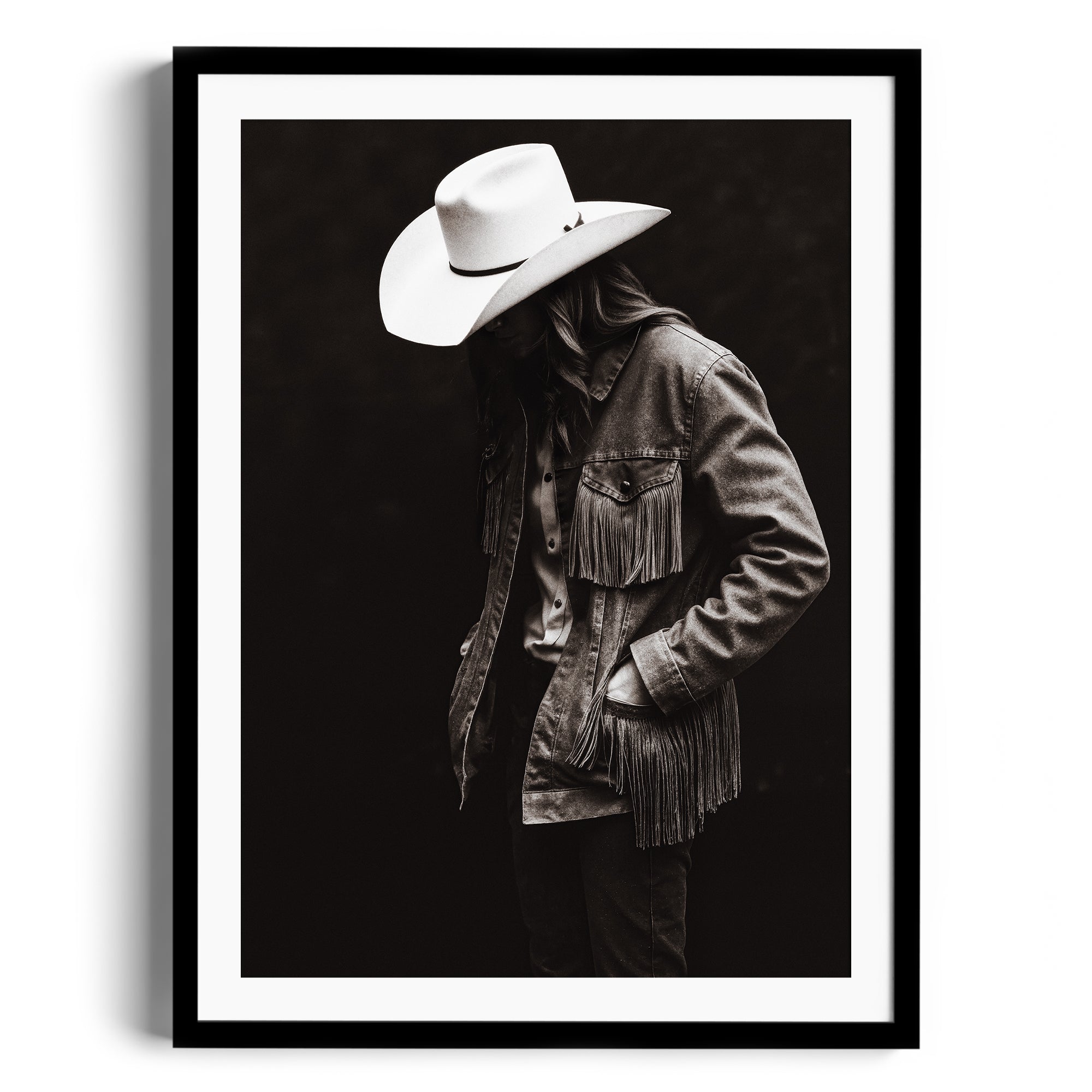 Black and white fine art portrait of a lone figure in a fringed denim jacket with a cowboy hat, representing Western spirit.