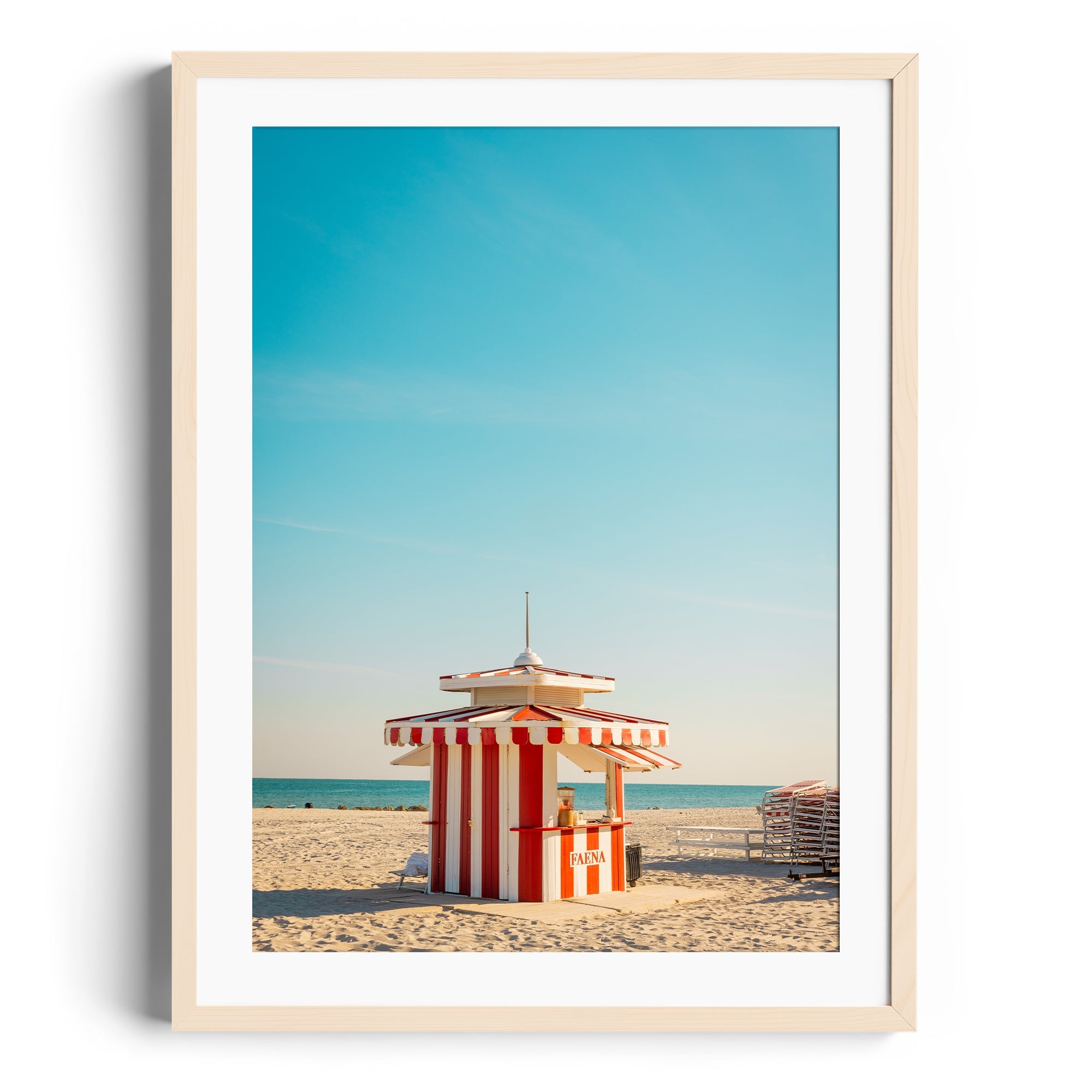 Framed fine art photography of a colorful striped beach hut on Miami's sandy shoreline, capturing vibrant coastal vibes.