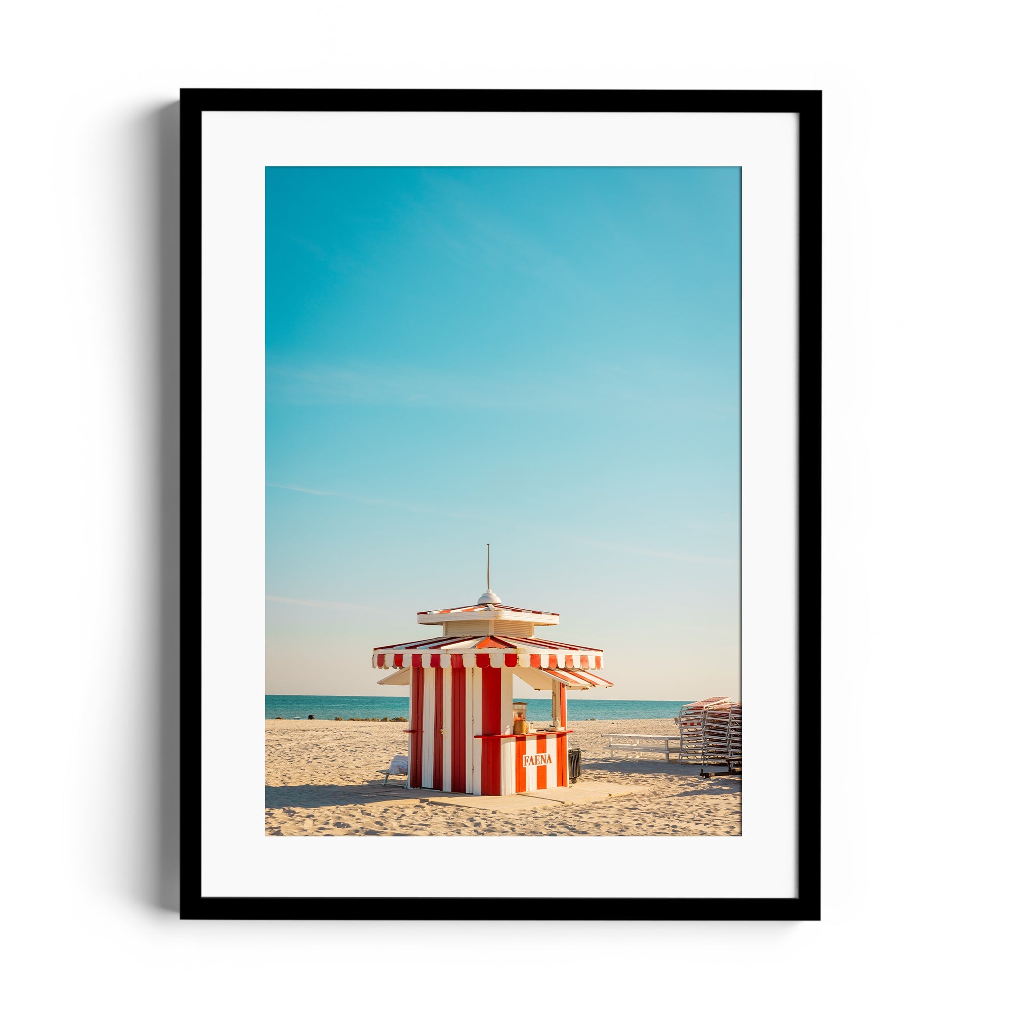 Framed fine art photograph of a striped beach kiosk under a blue sky, showcasing Miami's vibrant coastal beauty.