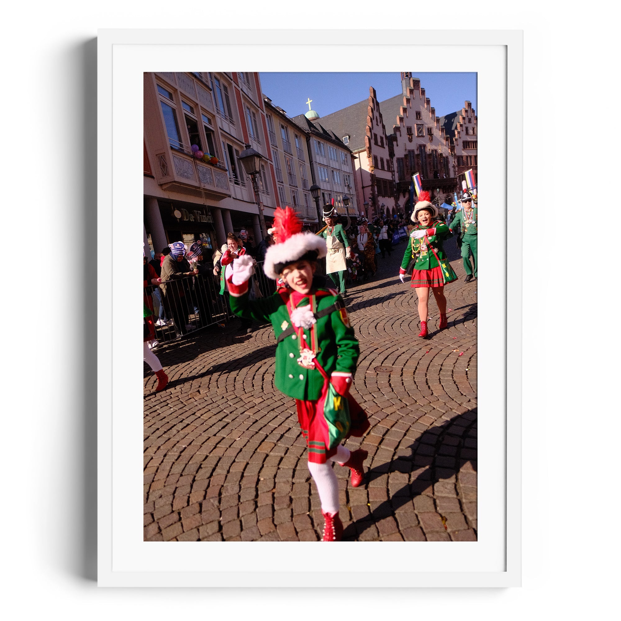 Festive parade scene featuring children in green outfits and festive hats, captured in a vibrant cobblestone street.