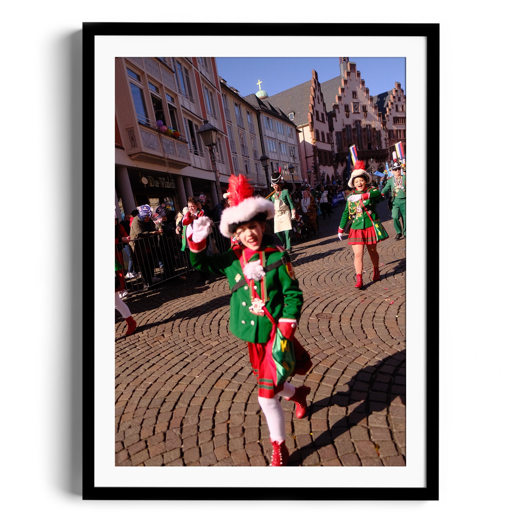Festive parade scene featuring children in green costumes and holiday accessories, captured in a charming cobblestone street.
