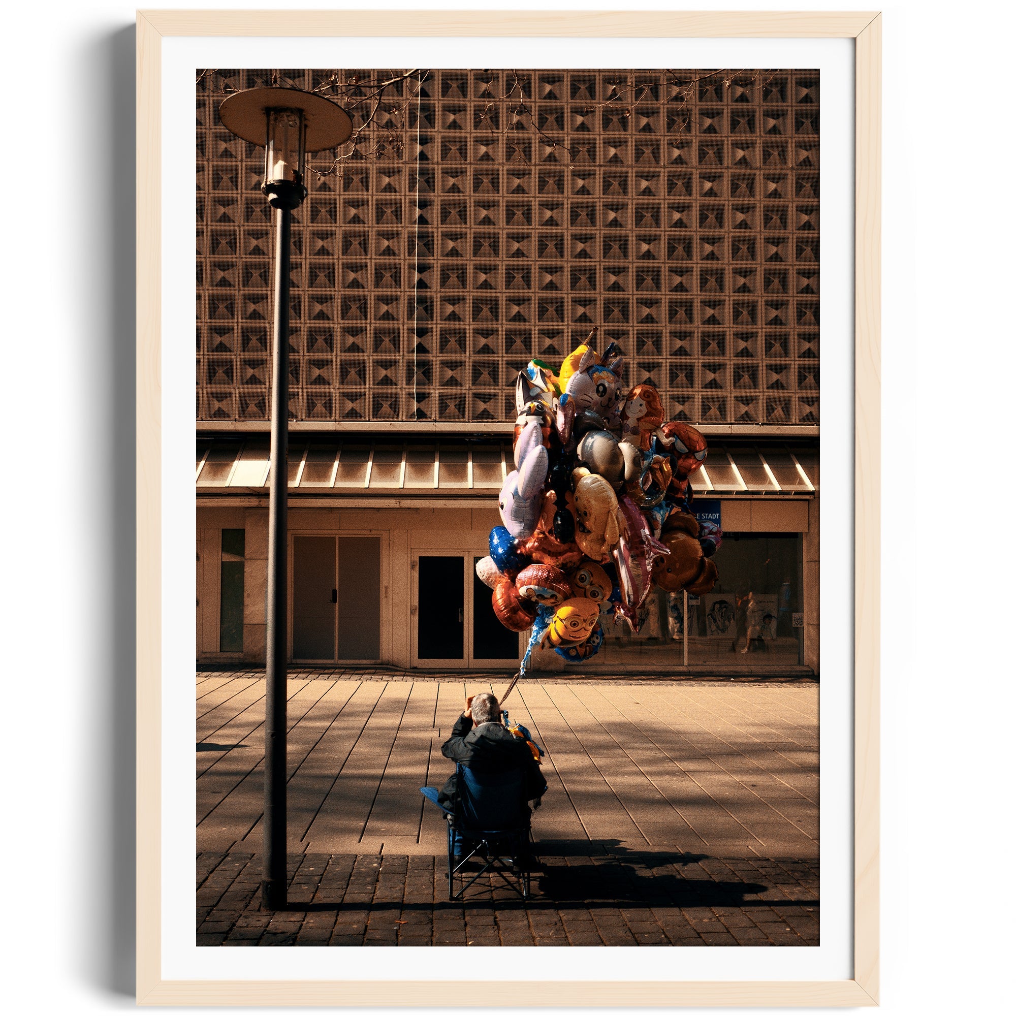 Framed fine art photography of a vendor selling colorful balloons in an urban setting by Marcelo Cadavid at The Dana Gallery, Miami.