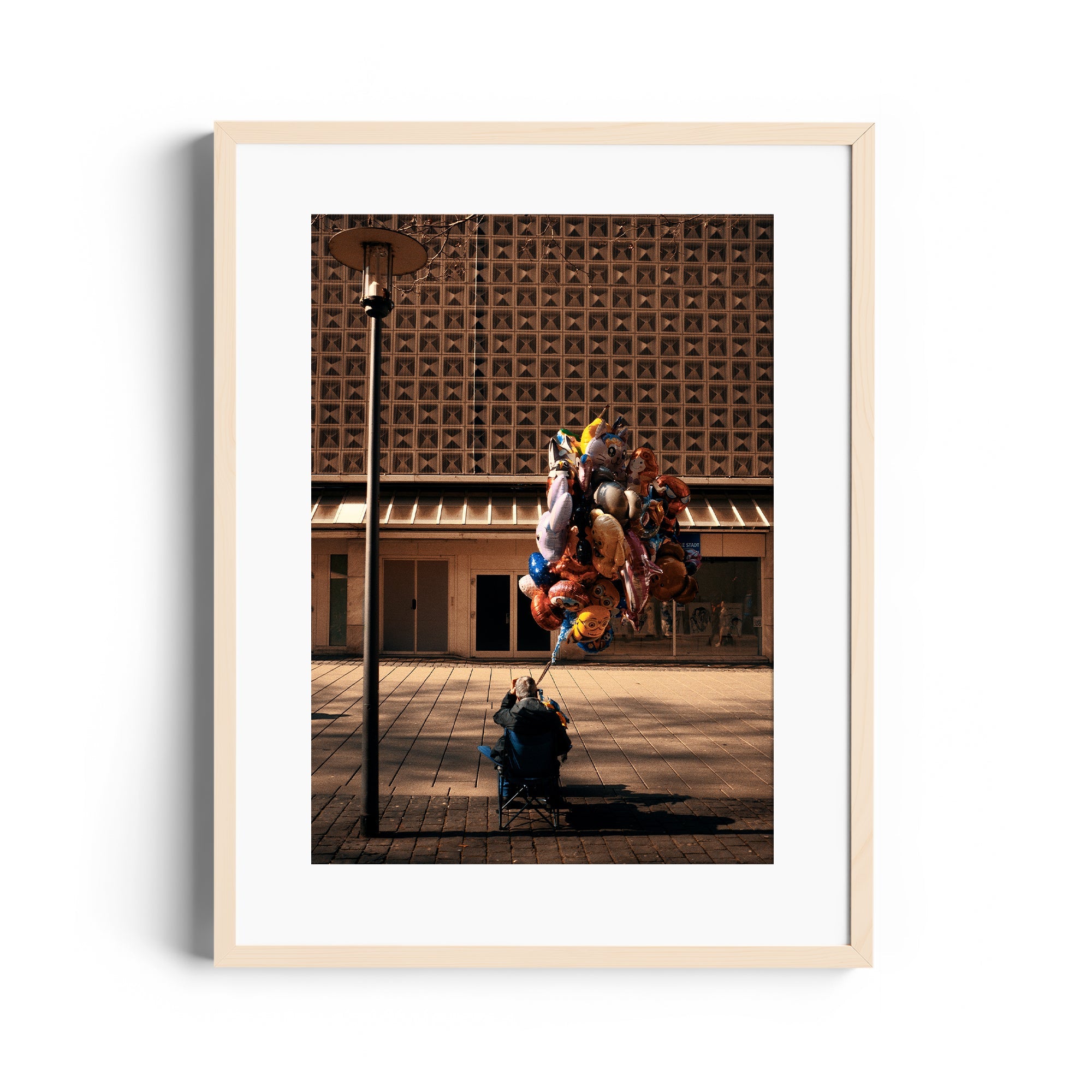 Framed fine art photography by Marcelo Cadavid featuring a figure with balloons in an urban setting.