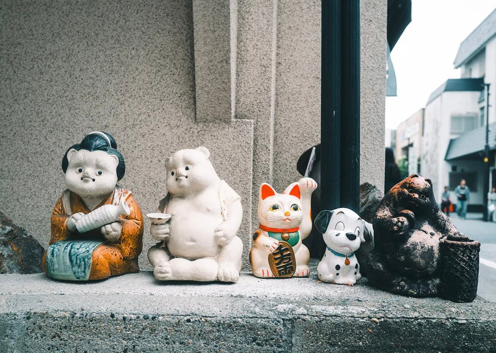 Collection of ceramic figurines on a ledge with a city street background