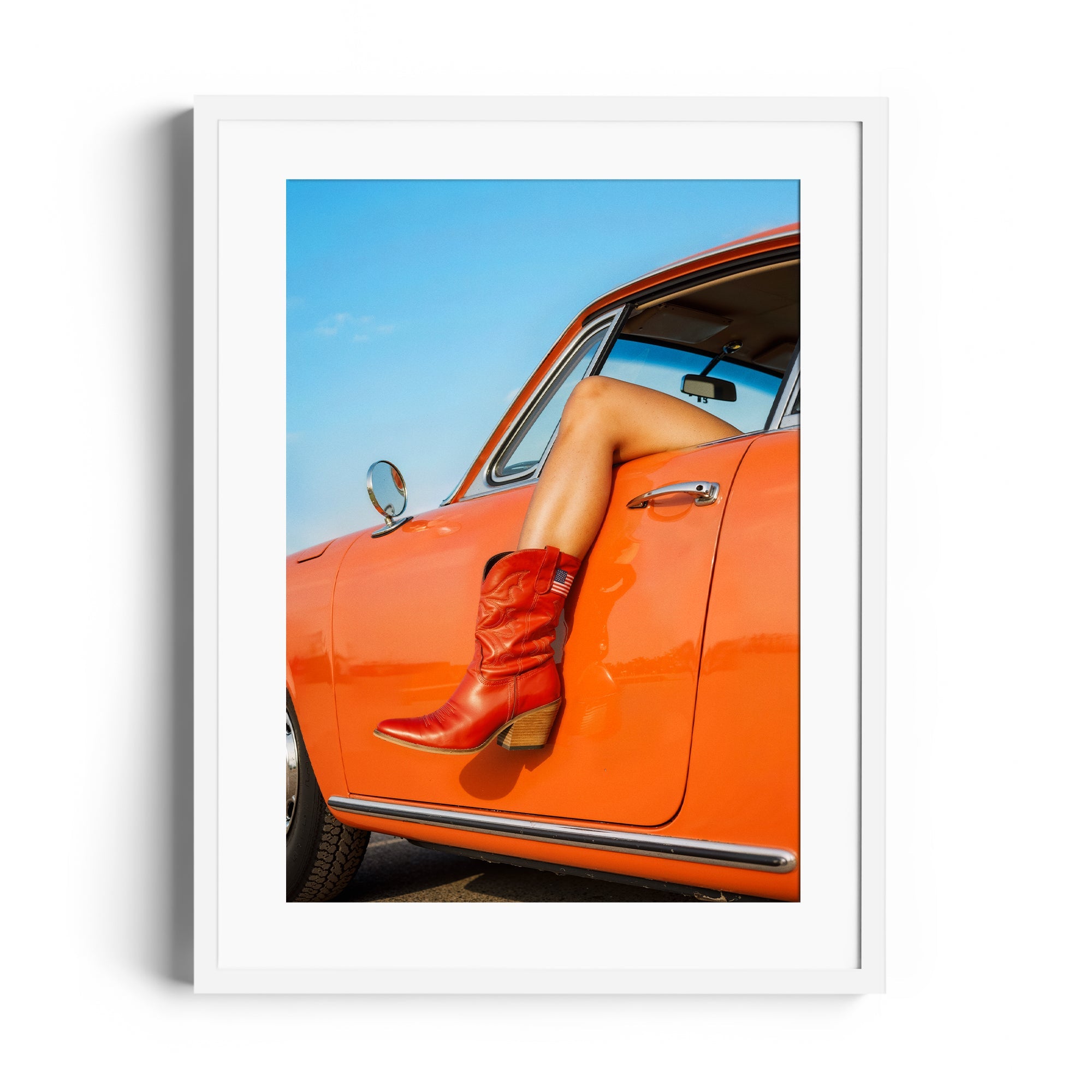 Red cowgirl boots showcased in an orange vintage car, reflecting Miami's vibrant art scene with fine art gallery quality.