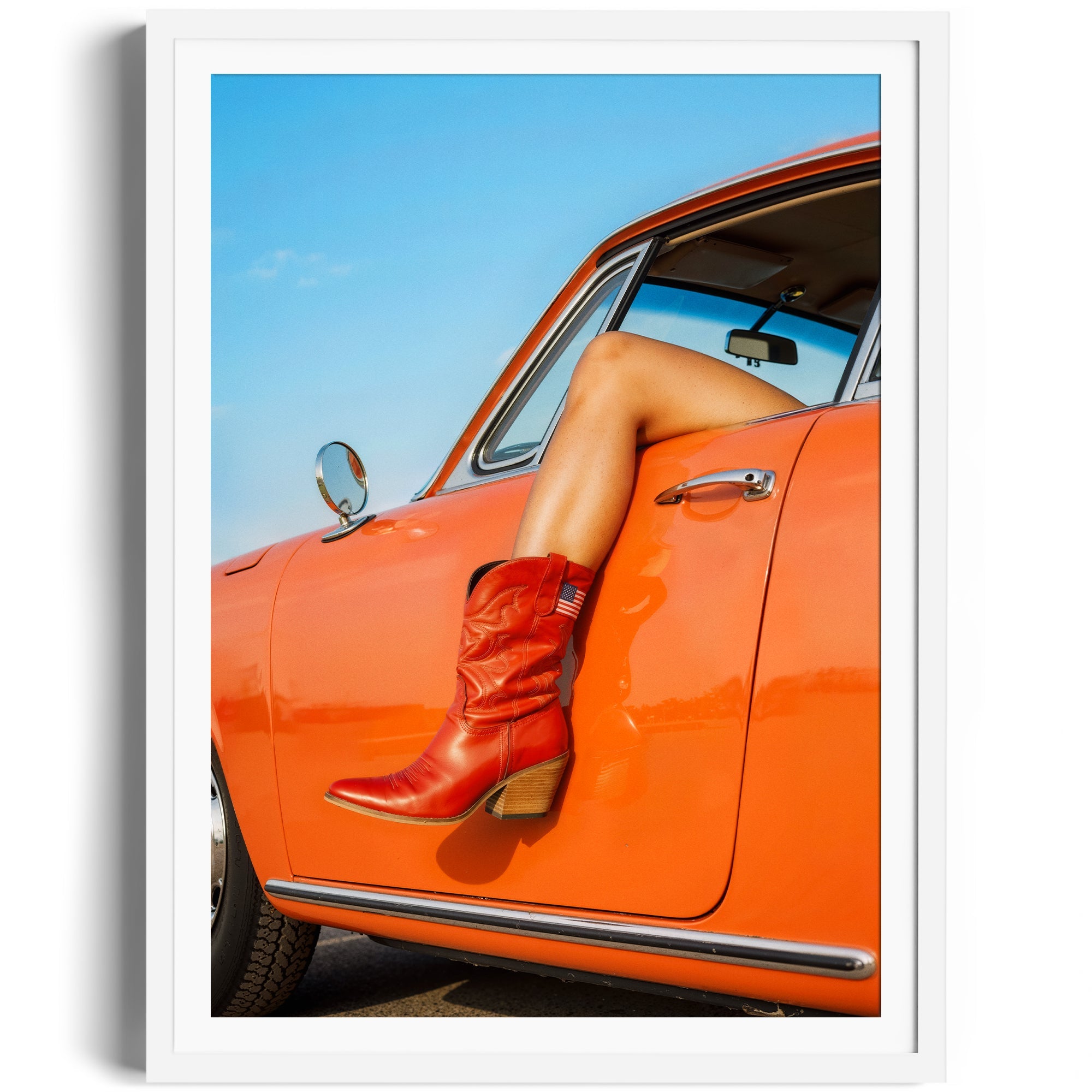 Vibrant cowgirl boots resting on the door of an orange vintage car, showcasing a stylish and adventurous lifestyle.