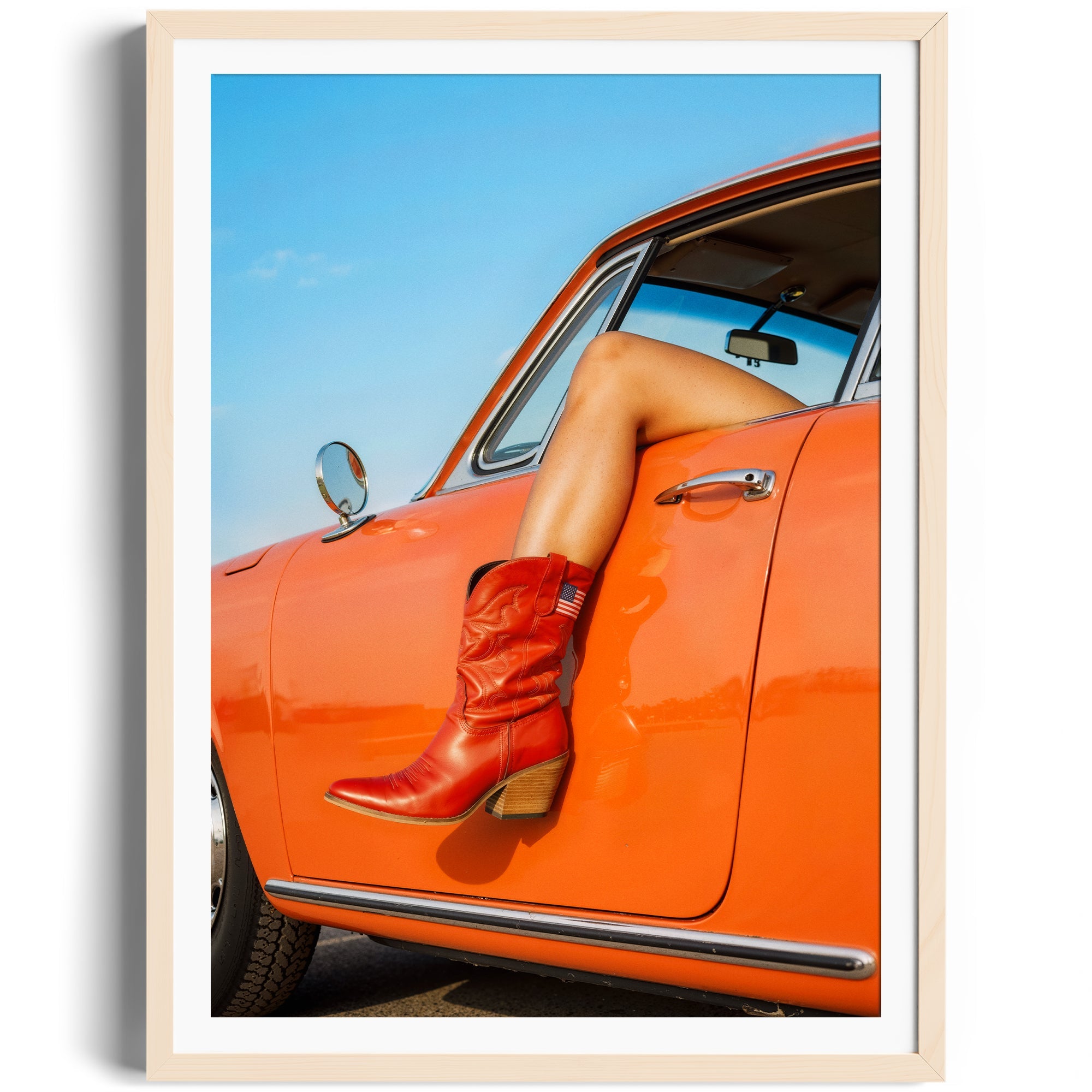 Red cowgirl boots resting on a car door, showcasing fine art photography in a vibrant setting. Perfect for gallery displays.