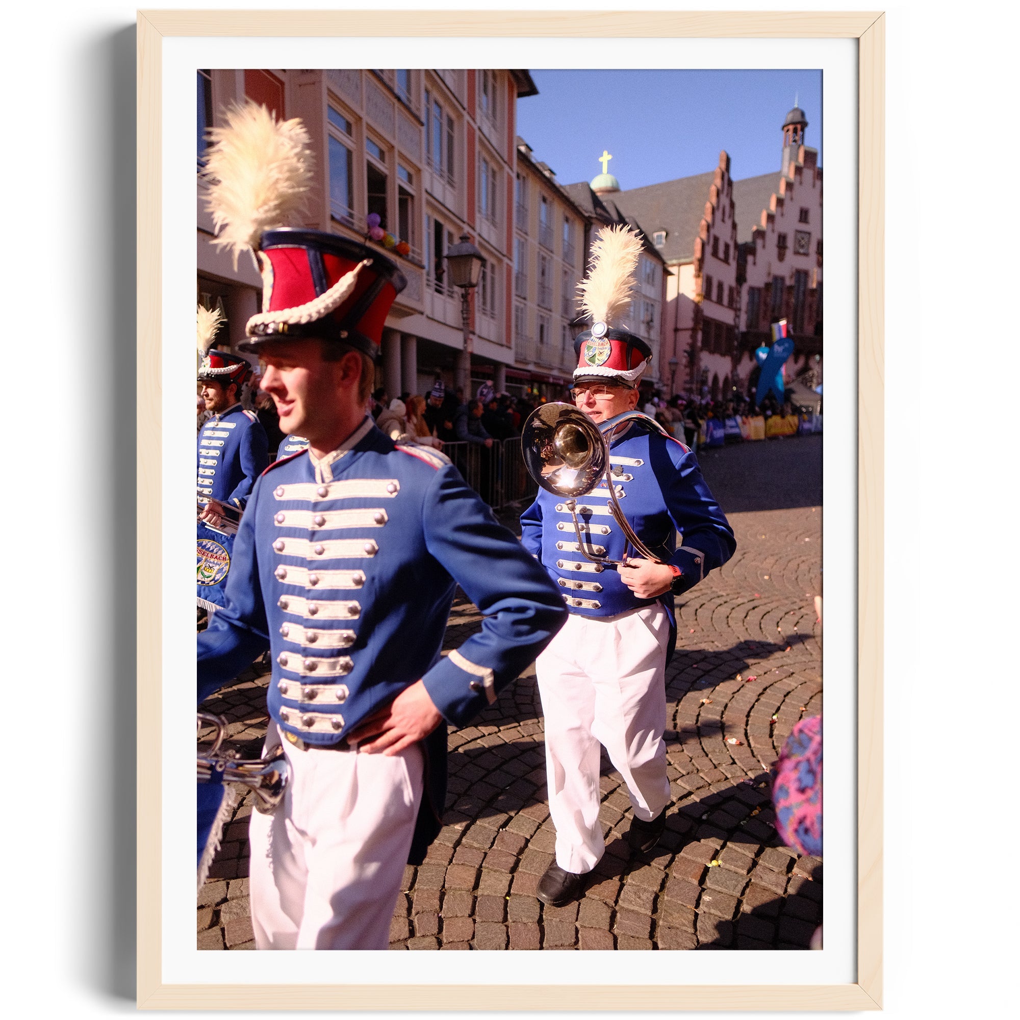 Marching band members in blue uniforms parading in a historic street, capturing vibrant cultural celebration.
