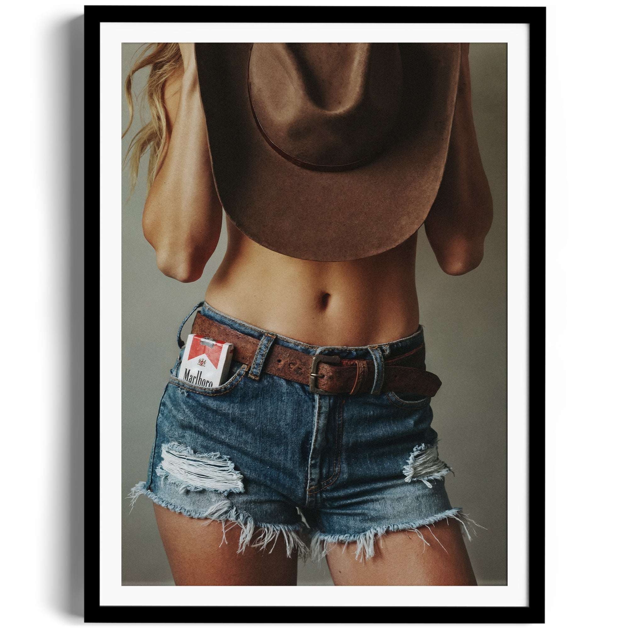 Limited edition fine art photography of a woman in denim shorts and cowboy hat, capturing Western allure in Miami.