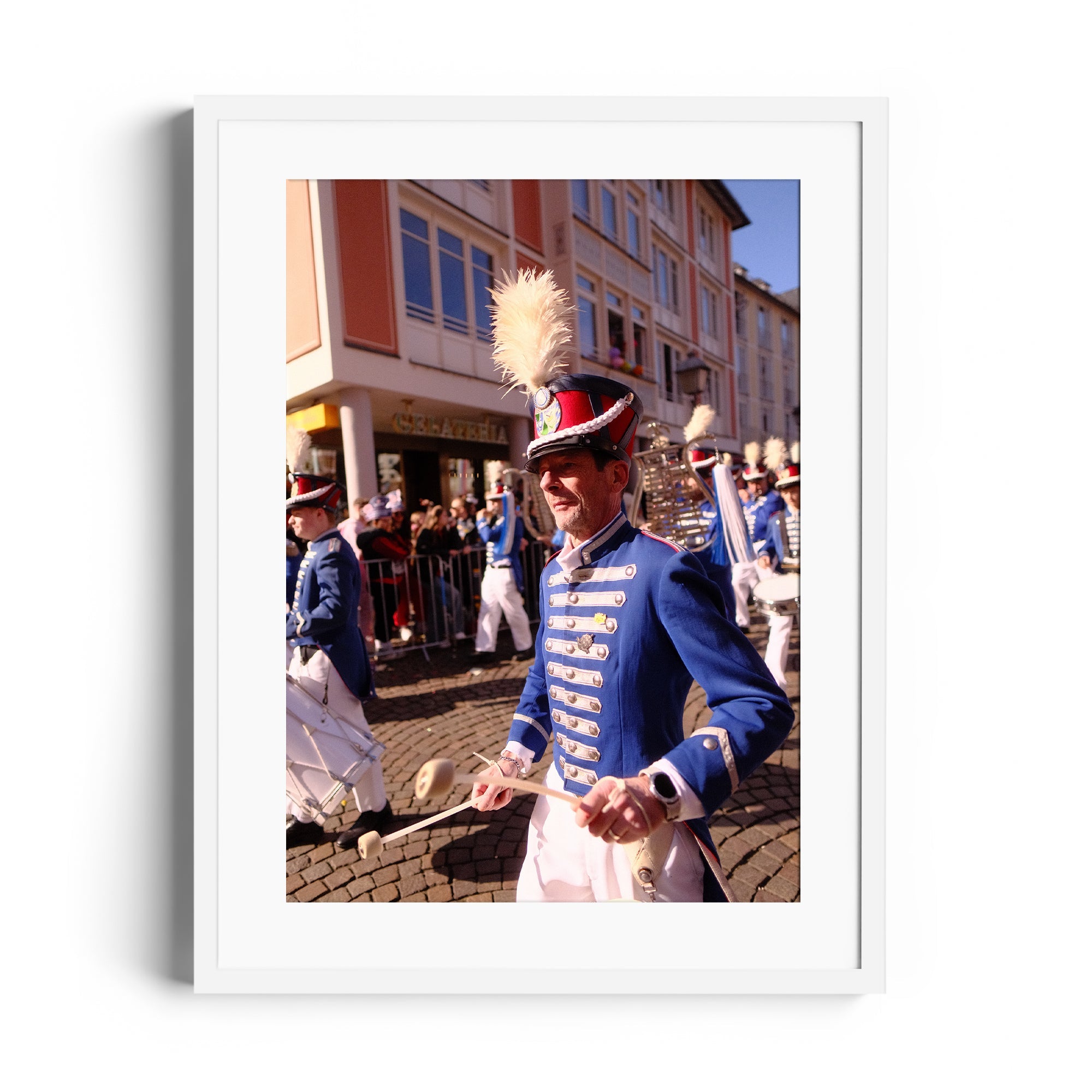 A man in a blue uniform with feathers parades at a festival, symbolizing spirited celebration and tradition.