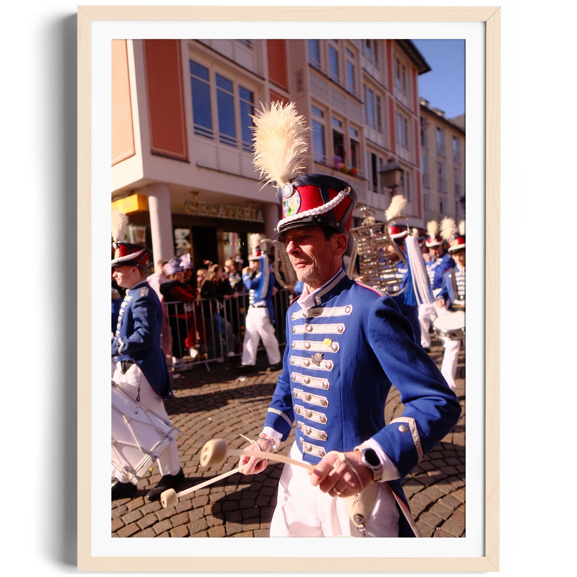 Drummer in blue uniform marching at a parade, framed in fine art style, capturing vibrant celebration.