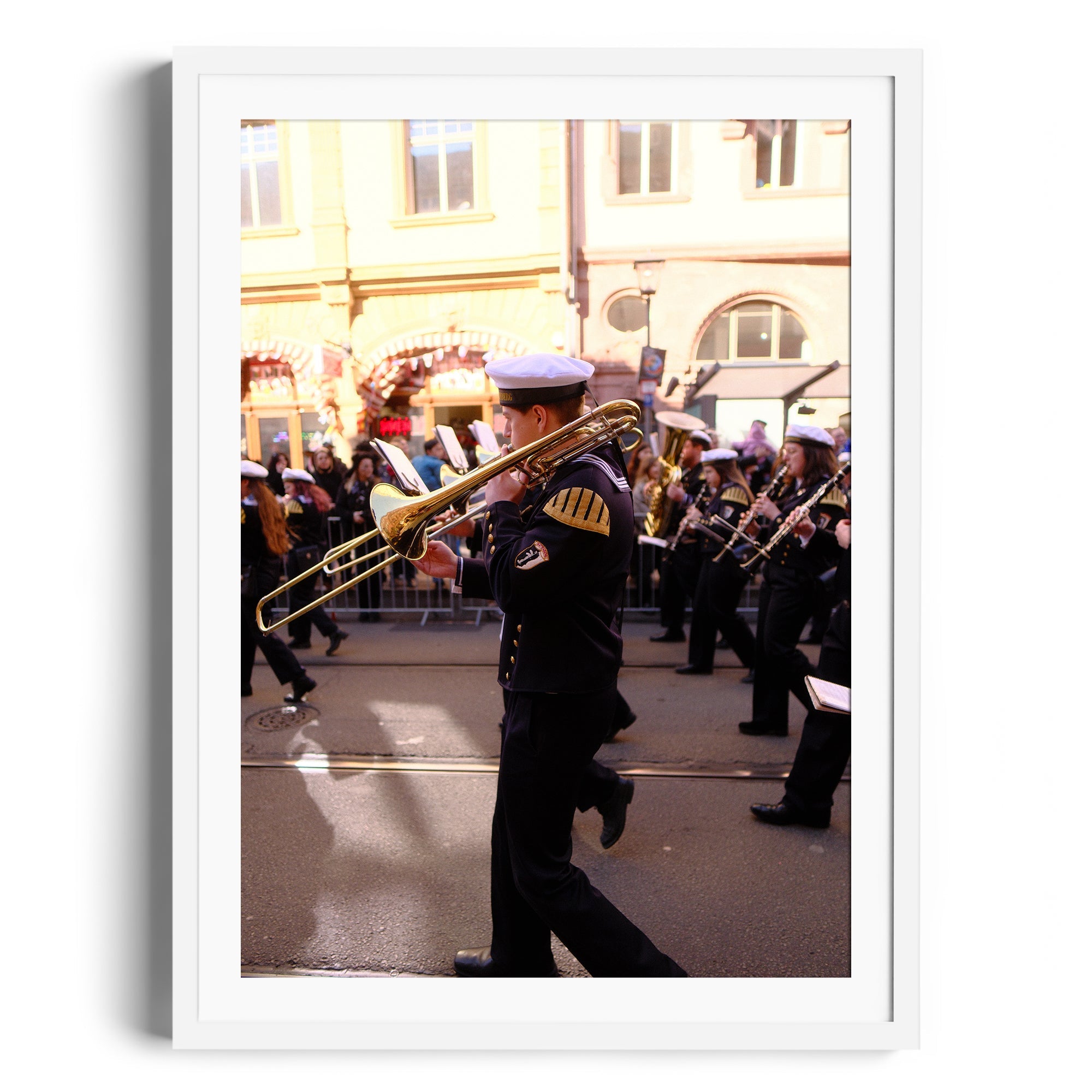 Fine art photograph of a musician playing trombone in a parade, displayed in a white frame, at The Dana Gallery Miami.