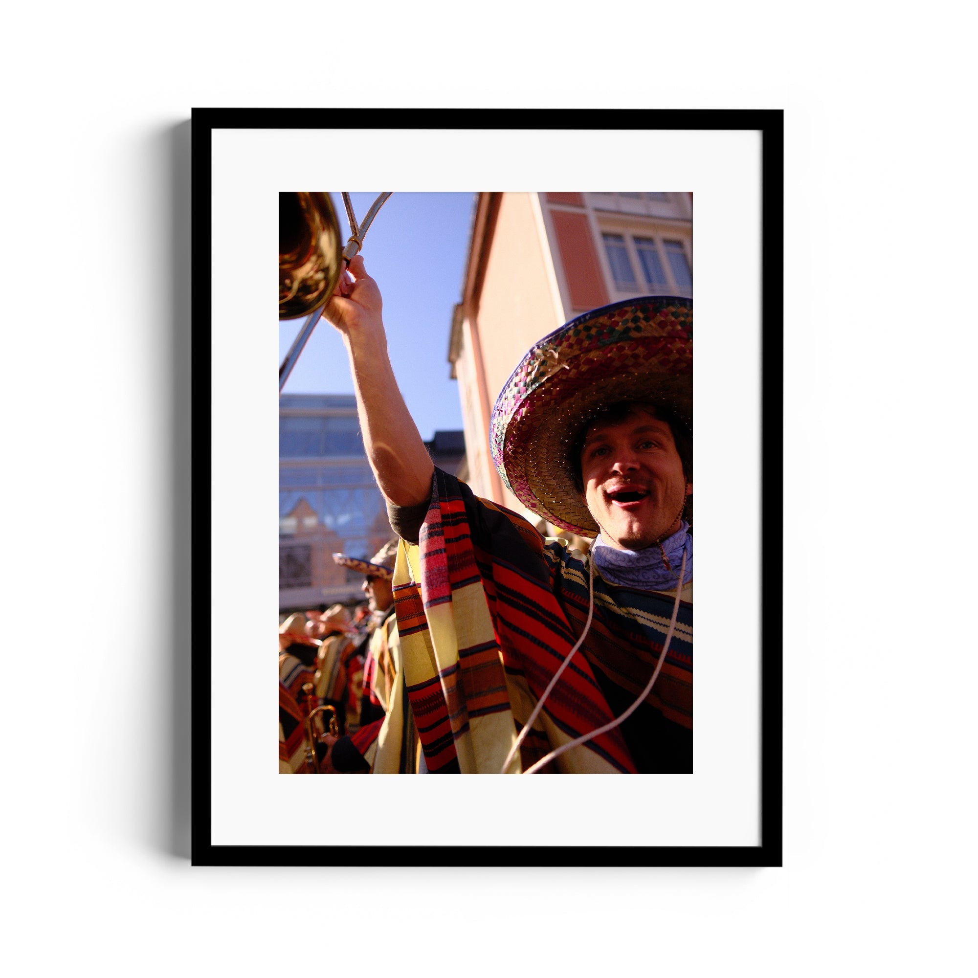 A joyful musician in a colorful poncho and sombrero playing trombone, captured in vibrant fine art photography.