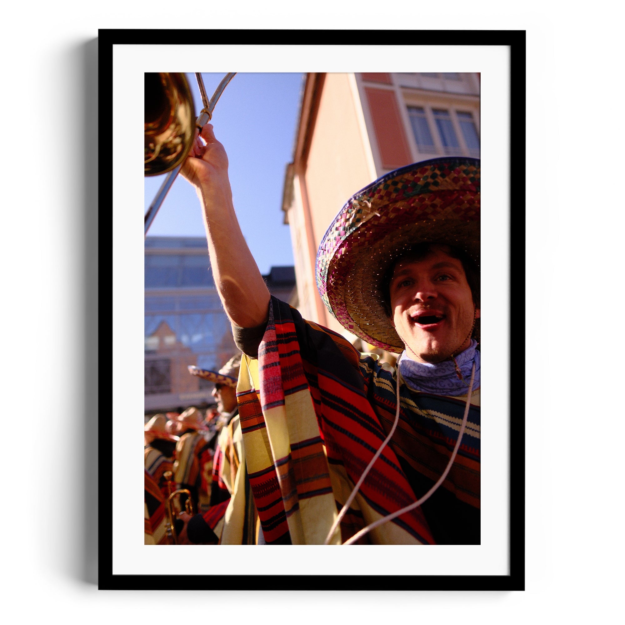 Cheerful musician in traditional attire playing trumpet outdoors, framed fine art photography by Marcelo Cadavid.