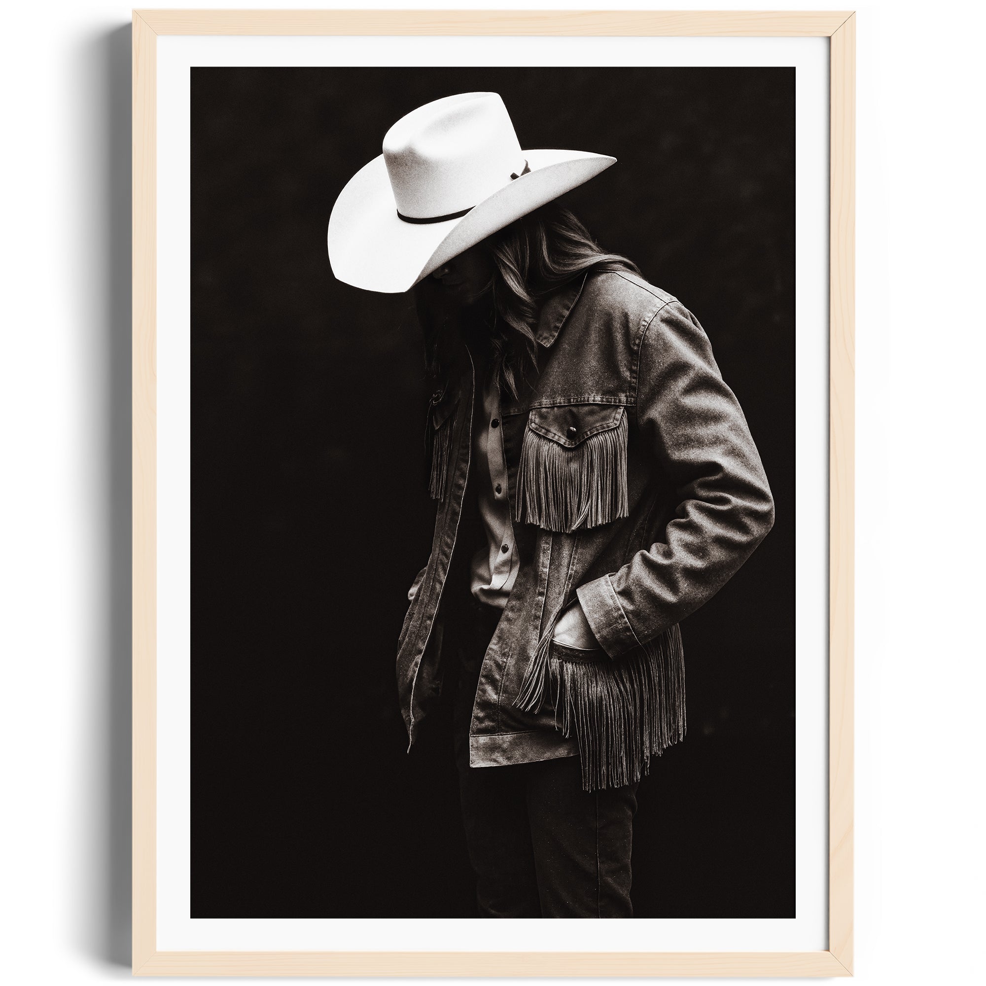 Monochrome portrait of a lone figure in fringed denim and cowboy hat, representing Western spirit in fine art photography.