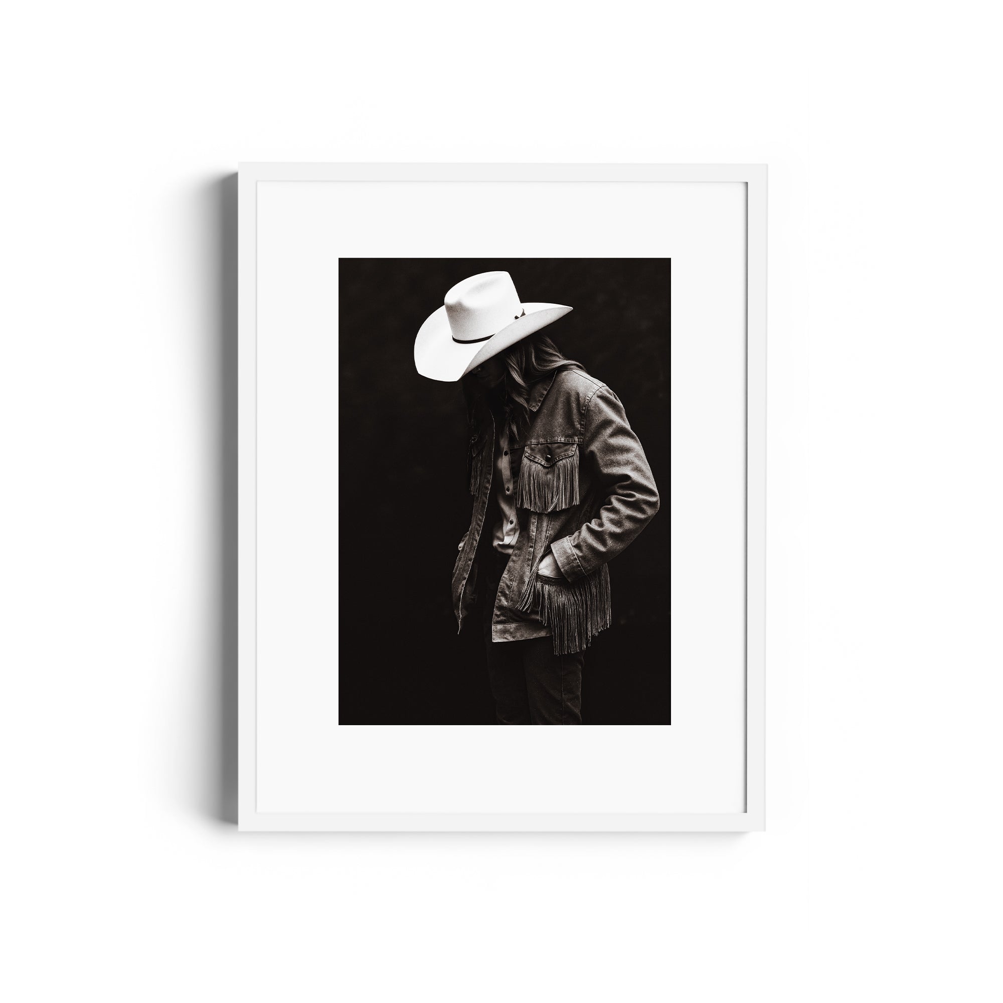 Monochromatic fine art print of a figure in a fringed denim jacket and cowboy hat, capturing the Western spirit. Fine art gallery Miami.
