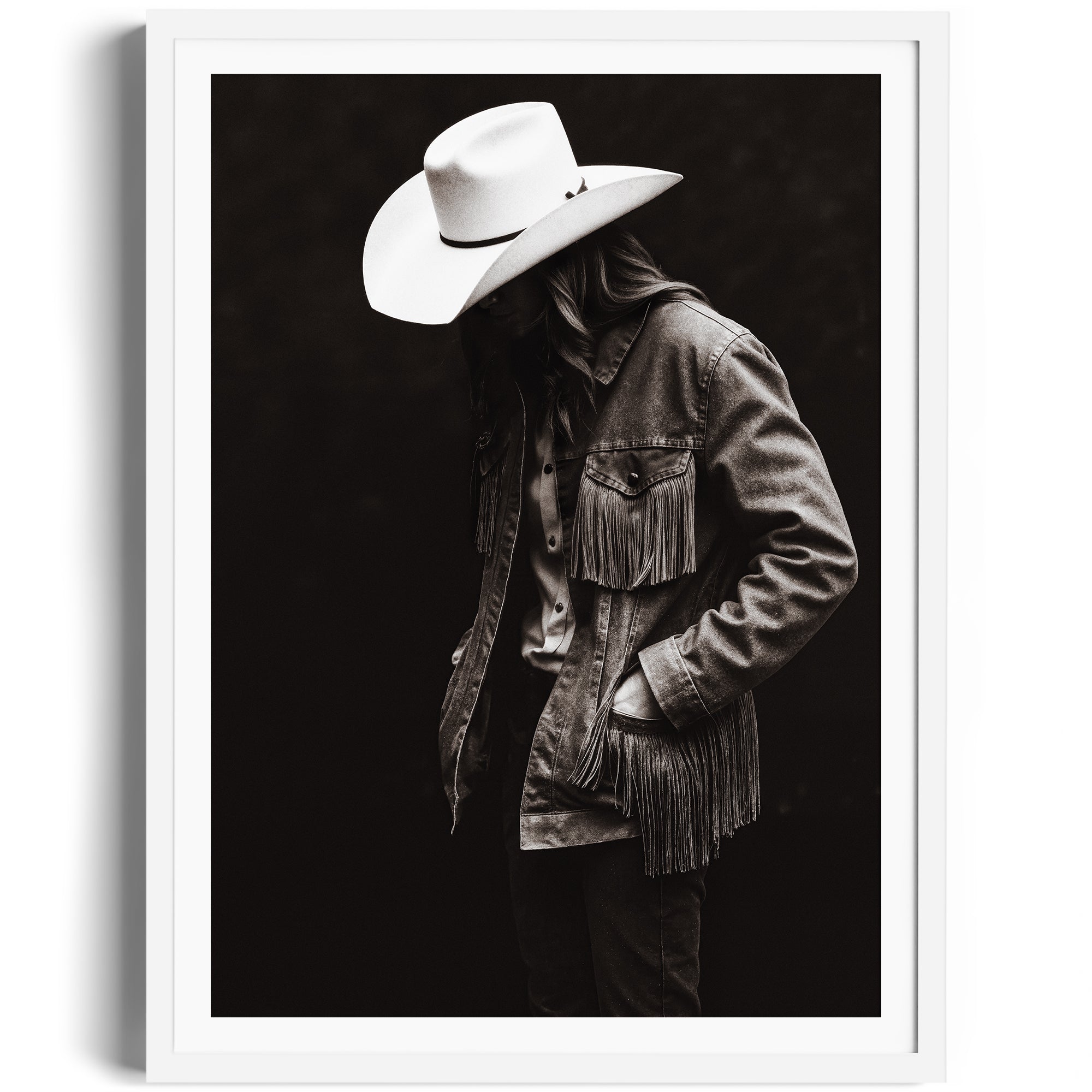 Monochrome portrait of a lone figure in a fringed denim jacket and cowboy hat, showcasing Western spirit and rugged independence.